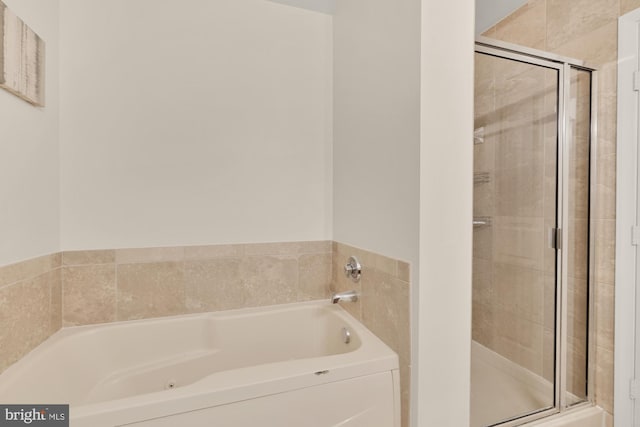 bathroom featuring a shower stall and a garden tub