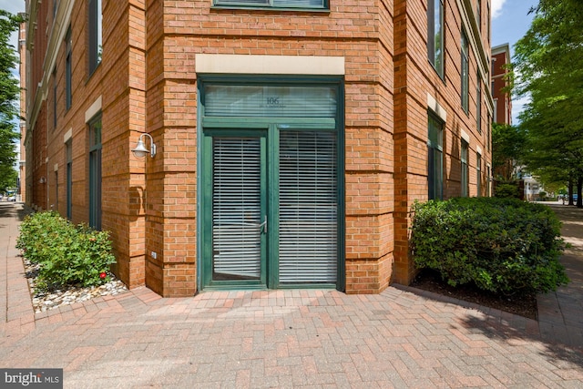 doorway to property with brick siding