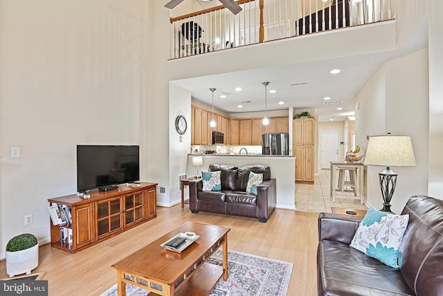 44365 Adare Manor Sq, Ashburn, VA 20147 - living room featuring light wood-style flooring, a towering ceiling, baseboards, and ceiling fan