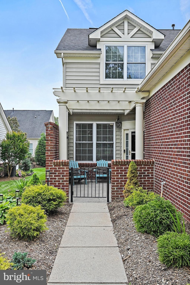 44365 Adare Manor Sq, Ashburn, VA 20147 - property entrance with a pergola, brick siding, a gate, and roof with shingles