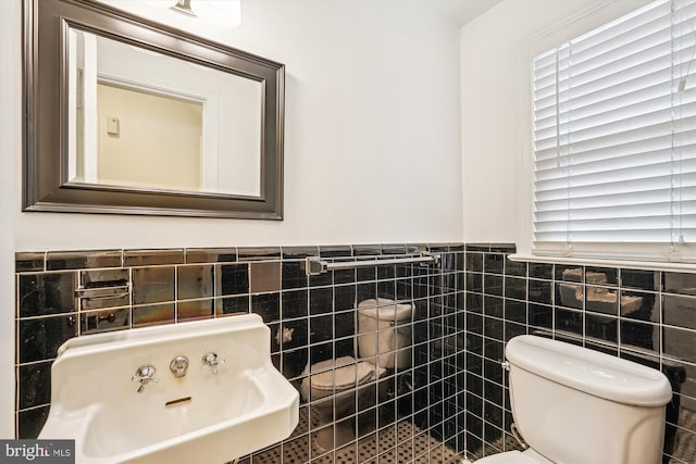 1918 Brisbane St, Silver Spring, MD 20902 - bathroom with tile walls, toilet, wainscoting, a sink, and plenty of natural light