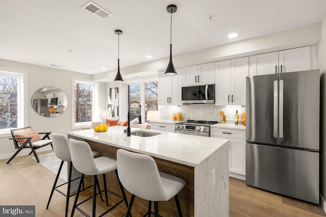 2639 41st St NW Unit 3, Washington, DC 20007 - kitchen featuring white cabinetry, tasteful backsplash, a sink, visible vents, and stainless steel appliances