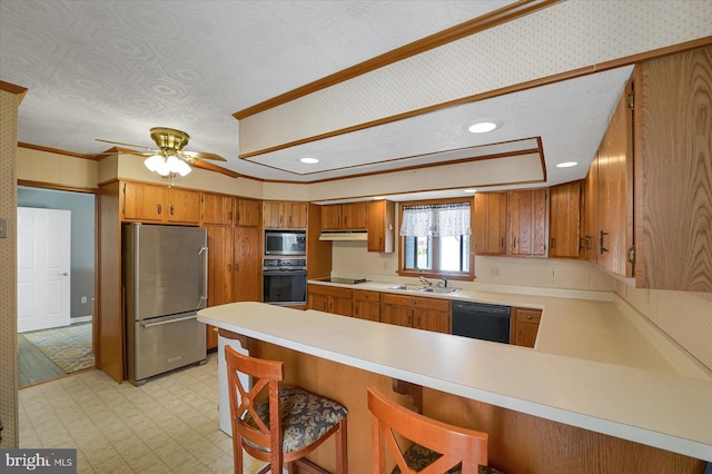 115 Penn St, Millheim, PA 16854 - kitchen with brown cabinetry, a peninsula, light floors, a sink, and black appliances
