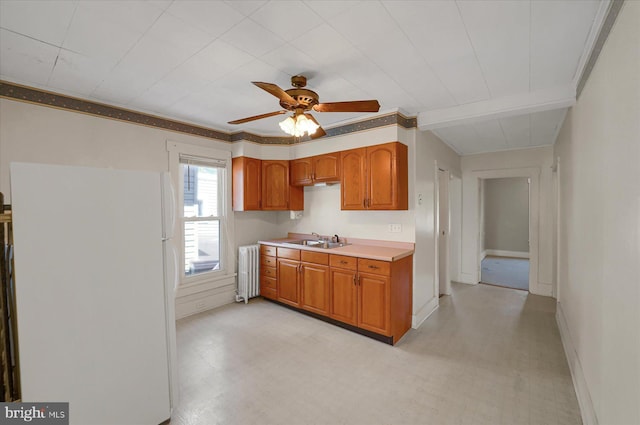 115 Penn St, Millheim, PA 16854 - kitchen featuring a sink, light countertops, radiator, freestanding refrigerator, and light floors