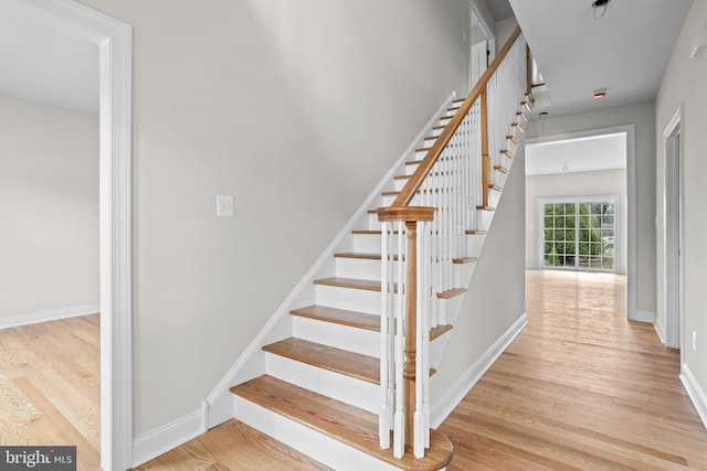 staircase with baseboards and wood finished floors