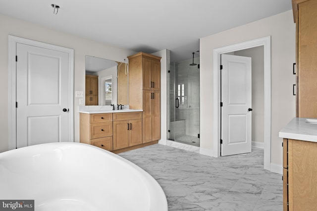 bathroom with marble finish floor, a freestanding tub, vanity, baseboards, and a stall shower