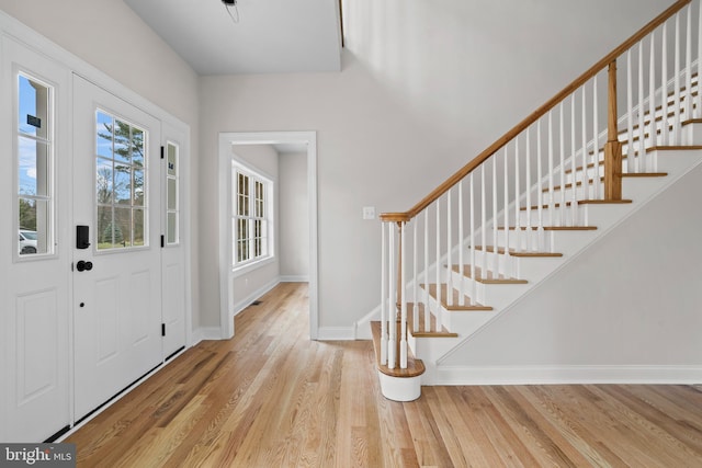entryway with baseboards, stairway, and wood finished floors