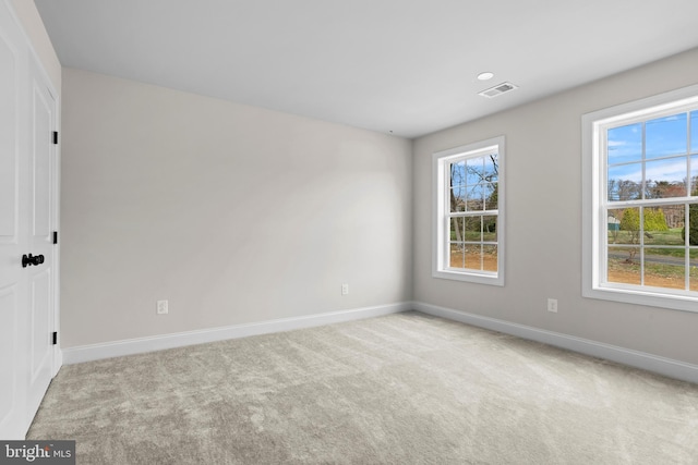 carpeted empty room with baseboards and visible vents
