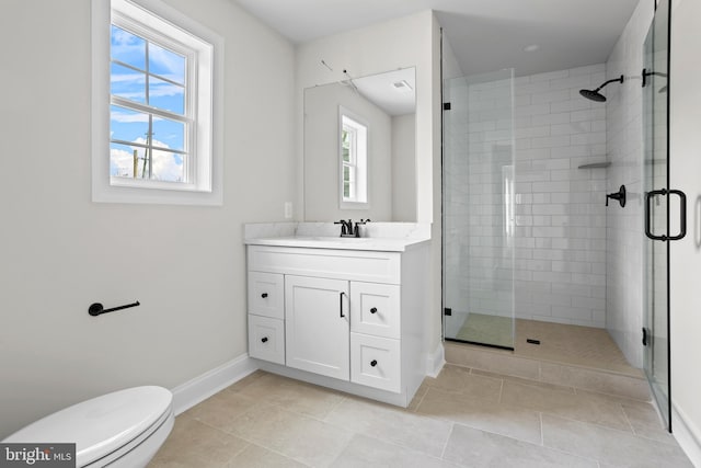 full bath featuring toilet, a stall shower, vanity, and baseboards