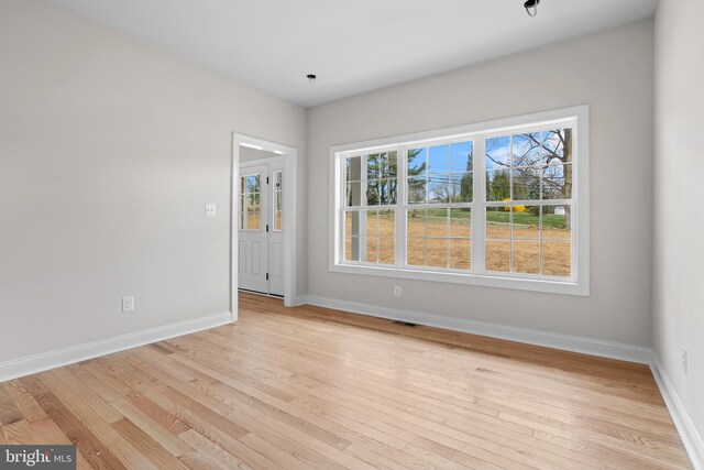 spare room with visible vents, baseboards, and light wood-type flooring