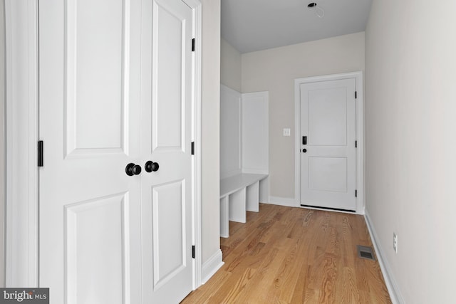 mudroom with visible vents, light wood-type flooring, and baseboards