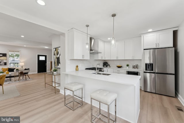 17 Longfellow St NW, Washington, DC 20011 - kitchen with stainless steel fridge, wall chimney range hood, recessed lighting, a kitchen bar, and light wood-type flooring