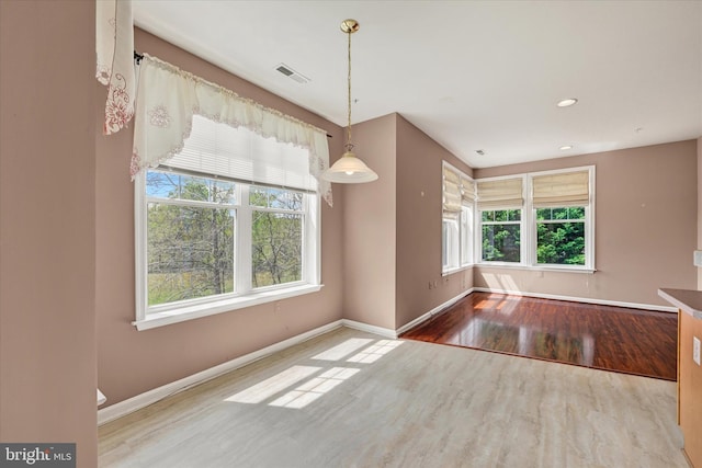 unfurnished dining area featuring wood finished floors, recessed lighting, visible vents, and baseboards