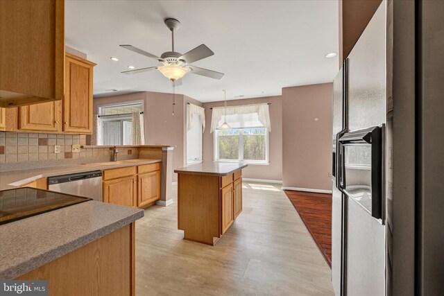 kitchen featuring tasteful backsplash, baseboards, light wood-type flooring, dishwasher, and a ceiling fan