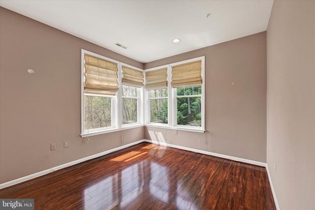 spare room featuring recessed lighting, visible vents, hardwood / wood-style flooring, and baseboards