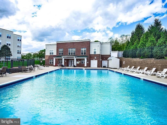 community pool featuring fence and a patio area