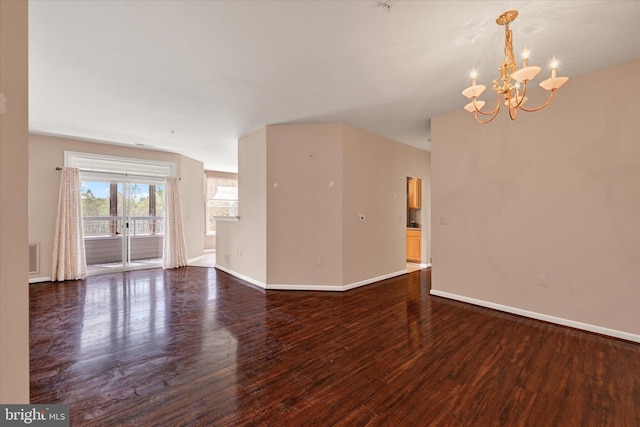 unfurnished living room featuring dark wood-style floors, baseboards, and a notable chandelier