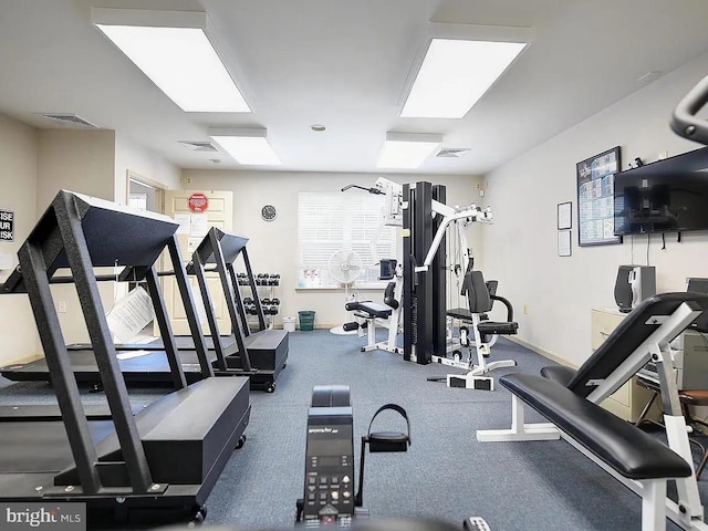 exercise room featuring baseboards, visible vents, and a wealth of natural light