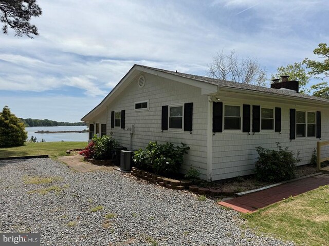 2260 Iberis Rd, Lancaster, VA 22503 - view of side of home featuring a chimney, central AC, a water view, and roof with shingles