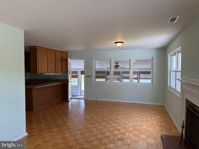 2260 Iberis Rd, Lancaster, VA 22503 - kitchen with brown cabinets, ceiling fan, visible vents, baseboards, and a fireplace
