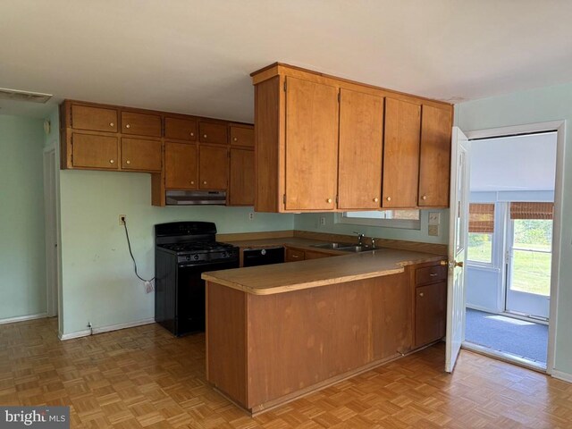 2260 Iberis Rd, Lancaster, VA 22503 - kitchen featuring brown cabinets, a sink, black range with gas stovetop, under cabinet range hood, and a peninsula
