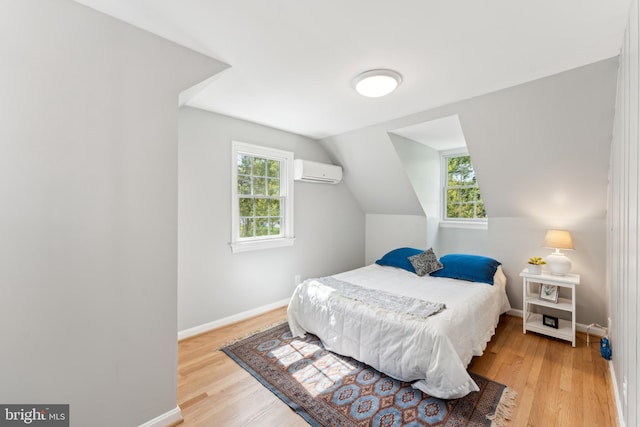 1111 Woodside Pkwy, Silver Spring, MD 20910 - bedroom with baseboards, a wall unit AC, wood finished floors, and lofted ceiling