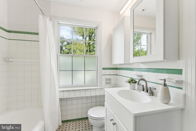 1111 Woodside Pkwy, Silver Spring, MD 20910 - bathroom with vanity, toilet, a wainscoted wall, tile walls, and shower / tub combo