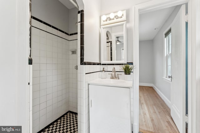 1111 Woodside Pkwy, Silver Spring, MD 20910 - full bath featuring wood finished floors, tile walls, tiled shower, and vanity