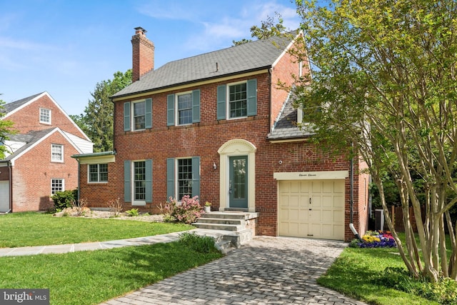 1111 Woodside Pkwy, Silver Spring, MD 20910 - colonial-style house with a front lawn, decorative driveway, a chimney, brick siding, and an attached garage