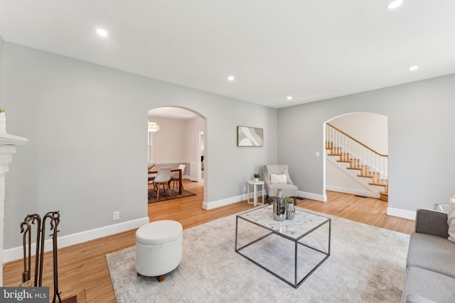 1111 Woodside Pkwy, Silver Spring, MD 20910 - living room with stairs, baseboards, recessed lighting, arched walkways, and light wood finished floors