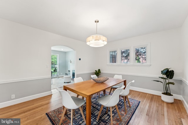1111 Woodside Pkwy, Silver Spring, MD 20910 - dining room with light wood-type flooring, arched walkways, and baseboards
