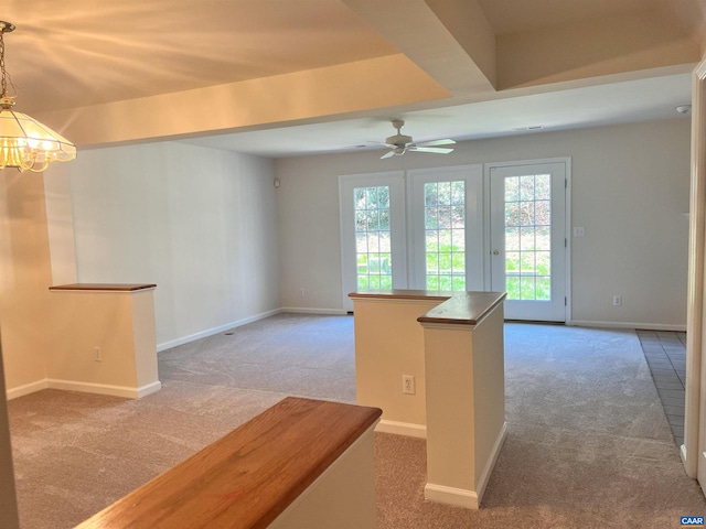 empty room with ceiling fan with notable chandelier, a wealth of natural light, carpet, and baseboards
