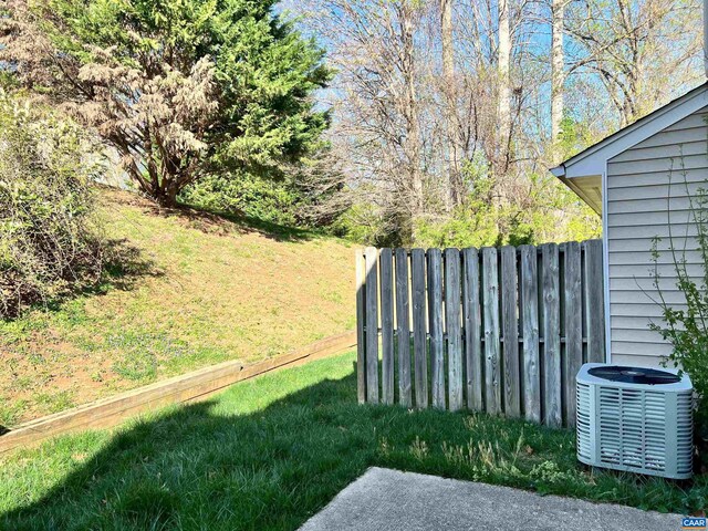 view of yard with fence and central AC