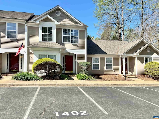 multi unit property featuring uncovered parking and roof with shingles