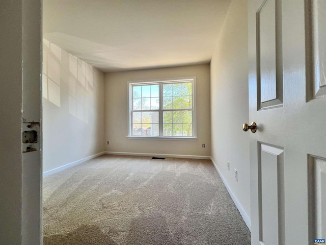 spare room with baseboards, visible vents, and carpet flooring