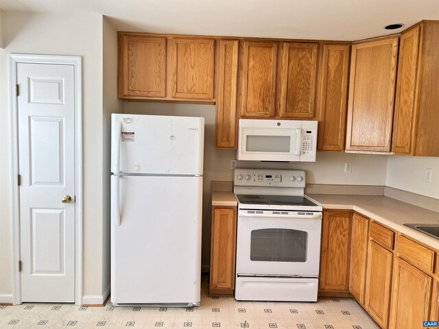 kitchen featuring light floors, white appliances, light countertops, and brown cabinetry