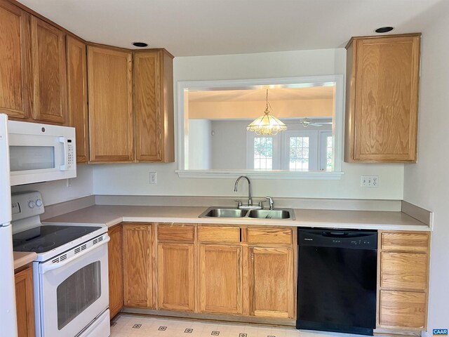 kitchen featuring brown cabinets, white appliances, light countertops, and a sink
