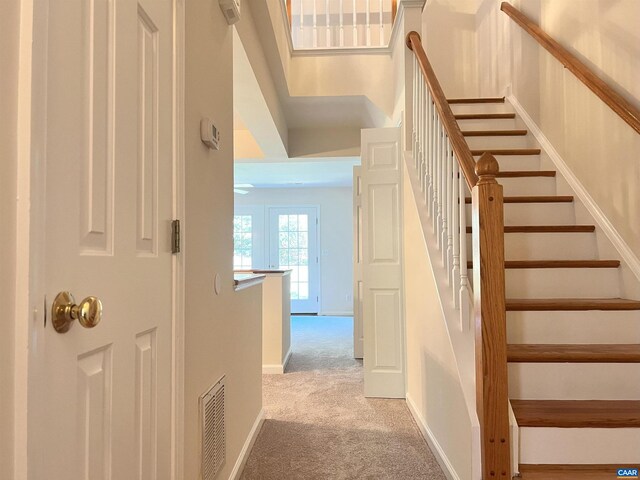 staircase featuring visible vents, carpet flooring, and baseboards