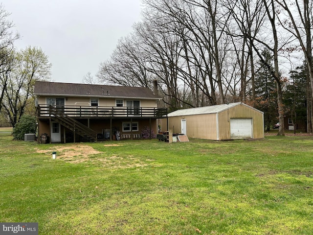 rear view of property with stairs, a detached garage, a wooden deck, an outdoor structure, and a yard