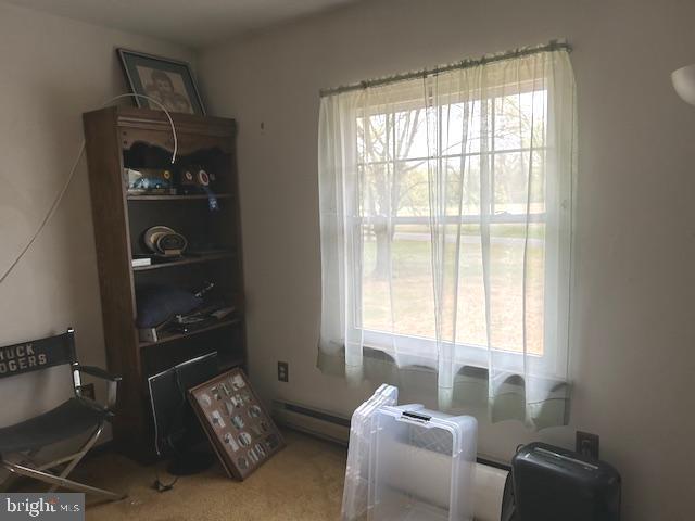 sitting room featuring a baseboard radiator and carpet flooring