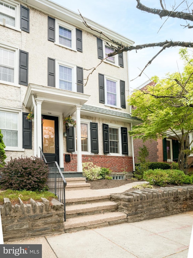 view of front facade featuring brick siding and stucco siding