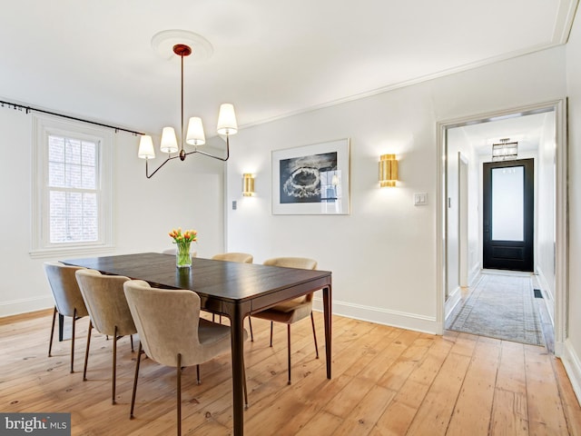 dining area featuring baseboards, a notable chandelier, and light wood-style floors