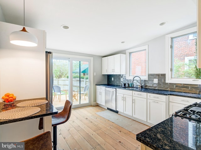 kitchen with a sink, light wood-style flooring, white cabinetry, tasteful backsplash, and stainless steel dishwasher