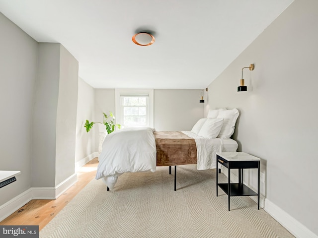 bedroom with baseboards and light wood finished floors