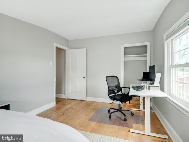 bedroom with baseboards, a closet, and wood finished floors