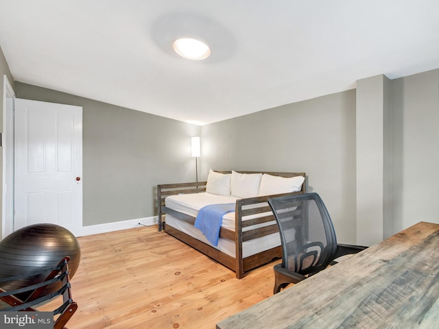 bedroom with baseboards and light wood-type flooring