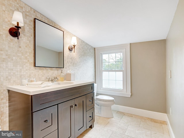 bathroom with baseboards, toilet, and vanity