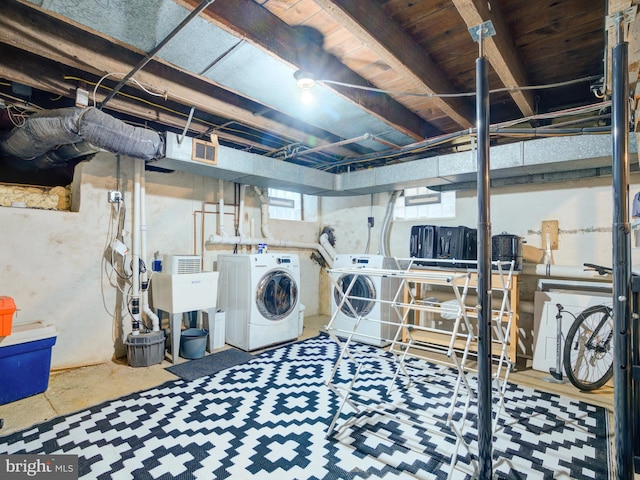 laundry area with independent washer and dryer, laundry area, and a sink