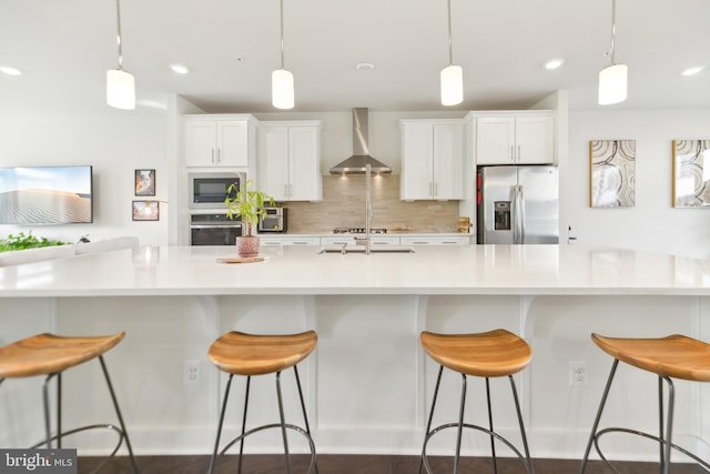 1702 River Sandstone Ter SE, Leesburg, VA 20175 - kitchen with stainless steel appliances, wall chimney range hood, white cabinets, decorative backsplash, and recessed lighting
