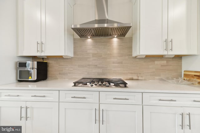 1702 River Sandstone Ter SE, Leesburg, VA 20175 - kitchen featuring wall chimney exhaust hood, stainless steel gas stovetop, light countertops, white cabinetry, and decorative backsplash